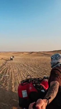 Romantik çift, büyük çöl manzarasını keşfederken el ele tutuşup bisiklet macerasından zevk alıyor.