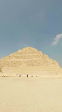 Çölde yürüyen turistler, saqara, Mısır 'da bir arkeoloji sahası olan djoser piramidinin yakınında yürüyorlar.