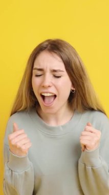 Heyecan, genç bir kadını canlı sarı bir arka planda çeşitli neşeli ifadelerle doldurur.