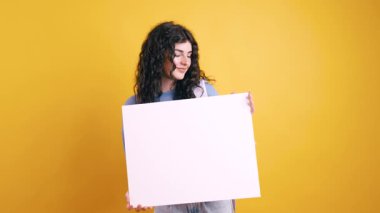 Sarı arka planda beyaz bir tahta sunan öğrenci, reklam ve eğitim içeriği için mükemmel.