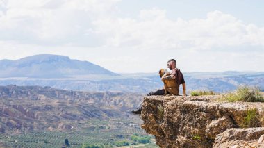 Turist köpeğiyle gorafe çölünün nefes kesici manzarasını seyrediyor, İspanya 'daki bir uçurumdan doğanın güzelliğini kucaklıyor.