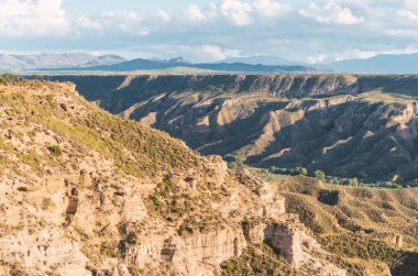 Güneş ışığı, Granada, Endülüs ve İspanya yakınlarındaki Gorafe Çölü 'ndeki neogen döneminin renkli kaya oluşumlarını ve uçurumlarını aydınlatıyor.