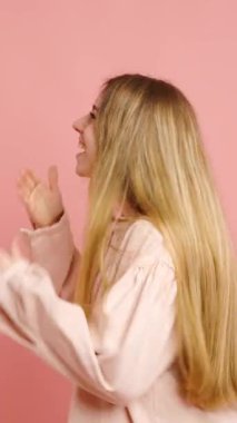 Heyecan, genç bir bayanı çeşitli neşeli ifadelerle doldurur. Canlı pembe bir arka planda izole edilmiş bir şekilde.