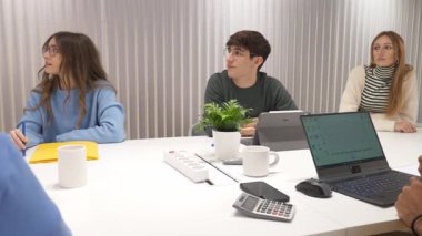 Stratejik tartışmalara katılan, verileri analiz eden ve verimli iş yeri toplantısında yenilikçi fikirlerin alışverişini yapan ortak girişim ekibi üyeleri