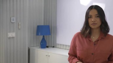 Modern bir ofiste sunum yapan kendine güvenen bir iş kadını, verimli bir toplantı sırasında ekibiyle meşgul oluyor.