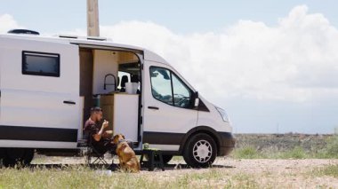 Turist, köpeğiyle birlikte İspanya 'nın Gorafe çölünde bir karavanda kahvaltı yapıyor.