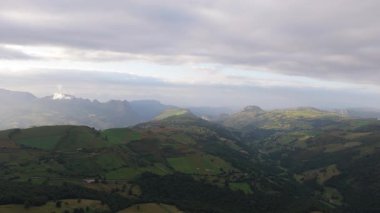 Yeşil vadiler ve dağlık arazi Cantabrian arazisi boyunca yayılıyor. Değişen bulutlu gökyüzünün altında dramatik hatları ortaya çıkarıyor. Yeşil kırsal alanda hafif doğal ışık yükseliyor.