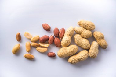 Organik fıstıklar kabuklarında tam bir fıstık koleksiyonu ve kabuksuz birkaç tane, protein açısından zengin fıstıklı sağlıklı atıştırma konsepti, beyaz arka planda izole edilmiş.. 