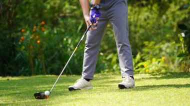 Akşam golf sahasında golf oynayan bir golfçü. Güneşin altında golf oynayan bir adam..                               