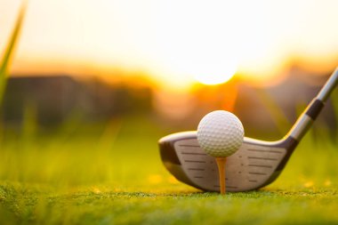 Golf sopaları ve golf topları yeşil çimlerde Sabah güneşli güzel bir golf sahasında.                                