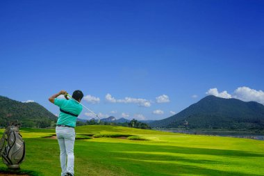 Akşam golf sahasında golf oynayan golfçü, güneş batımında akşam vakti golf oynayan adam, güneşin altında golf oynayan adam..                               