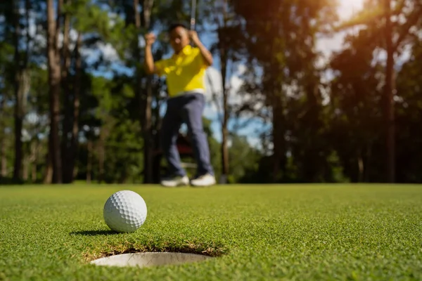 夜のゴルフコースでゴルフをプレイするぼやけたゴルファー 日没の夜の時間に 太陽の下でゴルフコースでゴルフをしている男 — ストック写真