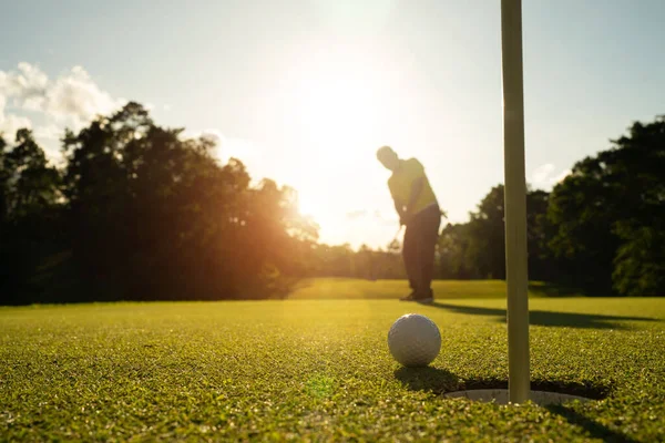 夜のゴルフコースでゴルフをプレイするぼやけたゴルファー 日没の夜の時間に 太陽の下でゴルフコースでゴルフをしている男 — ストック写真