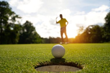 Bulanık golfçü akşam vakti golf sahasında golf oynuyor. Golfçüler akşam golf sahasına golf koyuyorlar. Spor tatil yaşam tarzı kavramı.