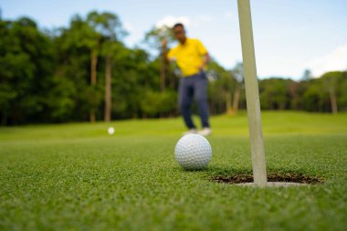 Bulanık golfçü akşam vakti golf sahasında golf oynuyor. Golfçüler akşam golf sahasına golf koyuyorlar. Spor tatil yaşam tarzı kavramı.