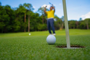 Bulanık golfçü akşam vakti golf sahasında golf oynuyor. Golfçüler akşam golf sahasına golf koyuyorlar. Spor tatil yaşam tarzı kavramı.