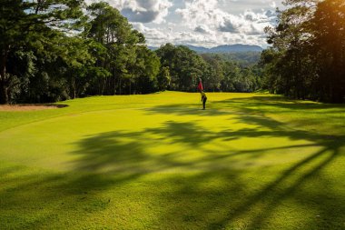 Bulanık golfçü akşam vakti golf sahasında golf oynuyor. Golfçüler akşam golf sahasına golf koyuyorlar. Spor tatil yaşam tarzı kavramı.