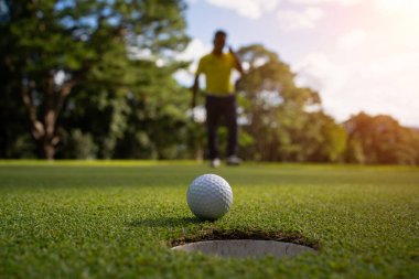 Bulanık golfçü akşam vakti golf sahasında golf oynuyor. Golfçüler akşam golf sahasına golf koyuyorlar. Spor tatil yaşam tarzı kavramı.