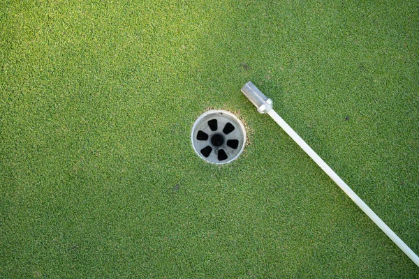 黄昏高尔夫球场绿地上的高尔夫球及高尔夫球旗 有日光浴 — 图库照片