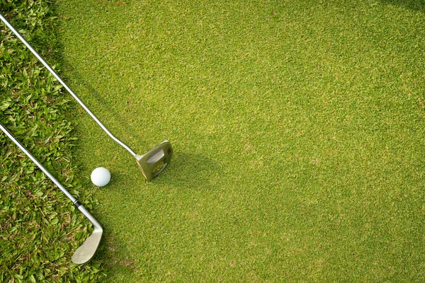 在有阳光的黄昏高尔夫球场的绿地高尔夫和高尔夫球杆 — 图库照片