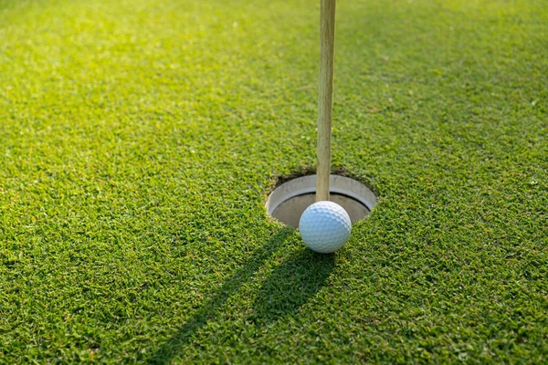 ゴルフボールは朝の日差しが美しいゴルフコースの緑の芝生の上にあります 世界中の人々が健康のための休日の間にプレイするスポーツ — ストック写真