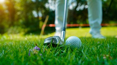 Tayland 'da güzel bir golf sahasında golf ve golf sopası. Yeşil arka planda yeşil çimenler üzerinde dinlenen golf ekipmanları koleksiyonu                               