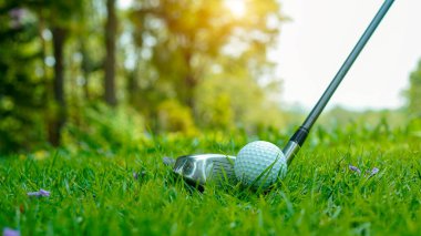 Tayland 'da güzel bir golf sahasında golf ve golf sopası. Yeşil arka planda yeşil çimenler üzerinde dinlenen golf ekipmanları koleksiyonu                               