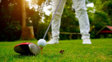 Akşam golf sahasında golf oynayan bir golfçü. Güneşin altında golf oynayan bir adam..                                
