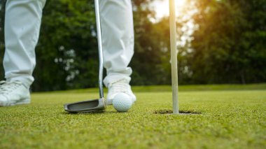 Golf topları gün batımında golf sahasında golf oyuncuları tarafından delik deşik edilecek. Golfçüler akşam saatlerinde golf sahasına golf oynuyorlar..                               