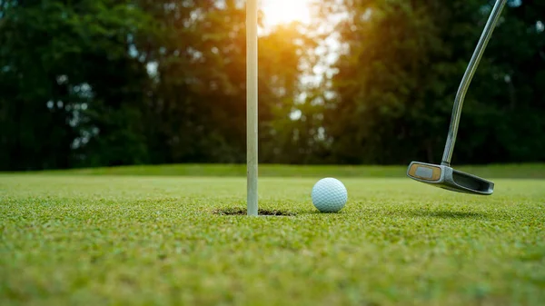 Golf topları gün batımında golf sahasında golf oyuncuları tarafından delik deşik edilecek. Golfçüler akşam saatlerinde golf sahasına golf oynuyorlar..                               