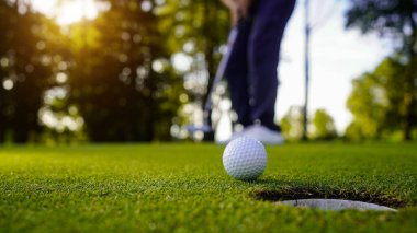 Bulanık golfçü akşam vakti golf sahasında golf oynuyor. Güneşin altında golf oynayan bir adam..                                
