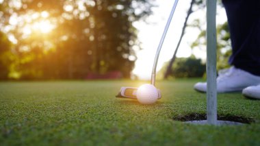 Bulanık golfçü akşam vakti golf sahasında golf oynuyor. Güneşin altında golf oynayan bir adam..                                