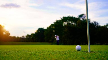 Bulanık golfçü akşam vakti golf sahasında golf oynuyor. Güneşin altında golf oynayan bir adam..                               