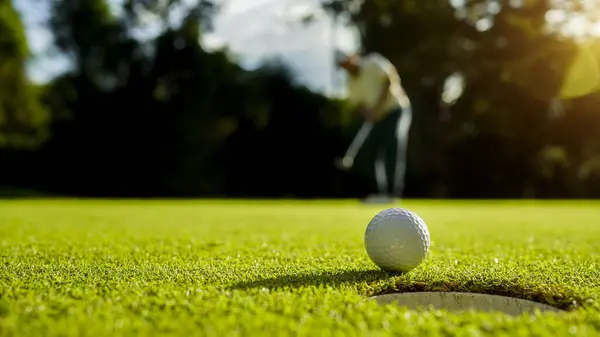 Bulanık golfçü akşam vakti golf sahasında golf oynuyor. Güneşin altında golf oynayan bir adam..                                