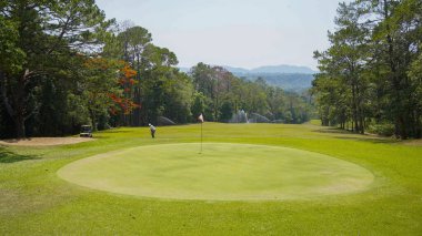 Akşam golf sahasında golf oynayan bir golfçü. Güneşin altında golf oynayan bir adam..                               