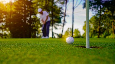 Bulanık golfçü akşam vakti golf sahasında golf oynuyor. Spor tatil yaşam tarzı kavramı.                                