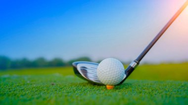 Golf topu ve golf sopası gün batımında arka planda güzel golf sahasında..                                                   