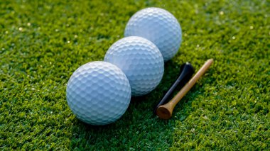 Golf topu yeşil çimlerin üzerinde sabah güneşli güzel bir golf sahasında. İlk kısa devrede golfe hazır..                               
