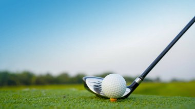 Golf sopaları ve golf topları yeşil çimlerde sabah güneşli güzel bir golf sahasında. Yeşil çimlerde golf ekipmanlarını kapatın..                                
