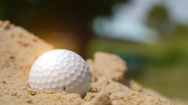 Sığınakta golf topu. Golf topu kumsalda güzel golf sahasında gün batımında arka planda.                               