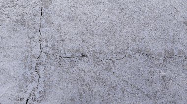 Beyaz duvar çatlamış beton. Arka planda çatlak olan eski çimento kırığı dokusu.