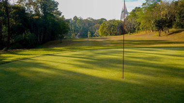 Golf sahasında yeşil çimenler ve ağaçlar. Golf sahasının manzarası ve güzel bir golf sahası. Zengin yeşil çimenlikli golf sahası. Güzel manzara..                                