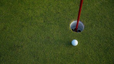 Üst Manzara. Akşam golf sahasında yeşil çimlerin üzerindeki golf deliği..                               