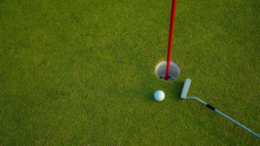 Üst Manzara. Akşam golf sahasında yeşil çimlerin üzerindeki golf deliği..                               