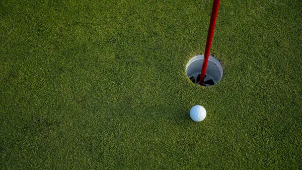 Üst Manzara. Akşam golf sahasında yeşil çimlerin üzerindeki golf deliği..                               