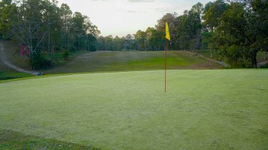 Golf sahasında yeşil çimenler ve ağaçlar. Golf sahasının manzarası ve güzel bir golf sahası. Zengin yeşil çimenlikli golf sahası. Güzel manzara..                                