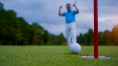 Golfçüler golfü akşam golf sahasına koyuyorlar. Golfçü golf topuna vuruyor. Spor tatil yaşam tarzı kavramı.                               