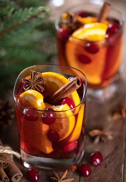 オレンジのスライス クランベリーとスパイスをバックグラウンドでクリスマスツリーの装飾と素朴な木製のテーブルの上に混在させたワイン — ストック写真