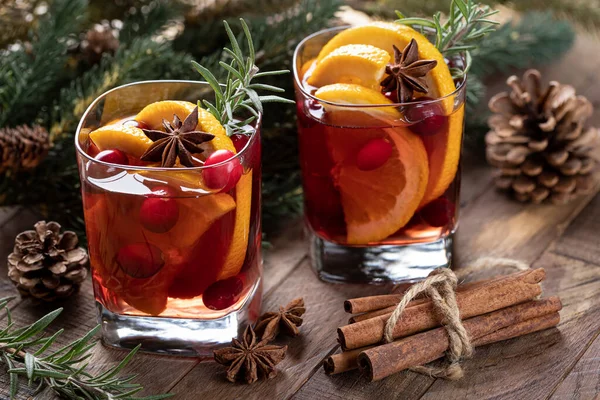 オレンジのスライス クランベリーとスパイスをバックグラウンドでクリスマスツリーの装飾と素朴な木製のテーブルの上に混在させたワイン — ストック写真