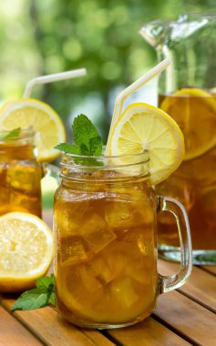 Buzlu çay bardakta, sürahi limonlu ve nane şekerli.